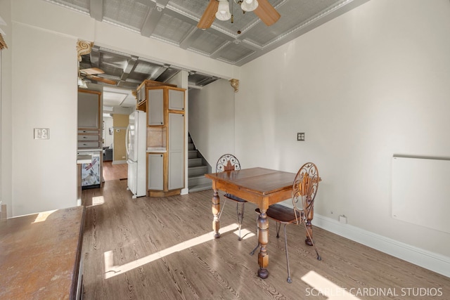 dining area with baseboards, stairs, a ceiling fan, and light wood-style floors