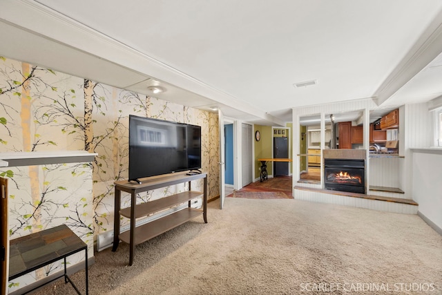 living area featuring visible vents, carpet flooring, a multi sided fireplace, baseboards, and wallpapered walls