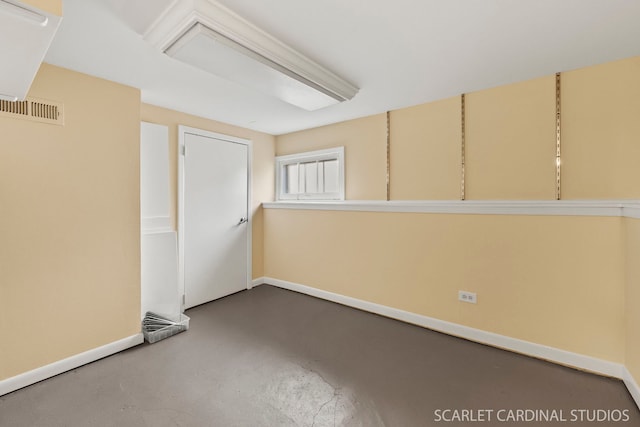 spare room with concrete flooring, visible vents, and baseboards