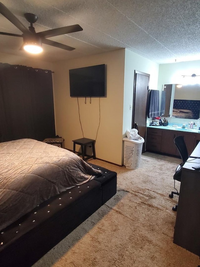 bedroom with ceiling fan, light carpet, and a textured ceiling