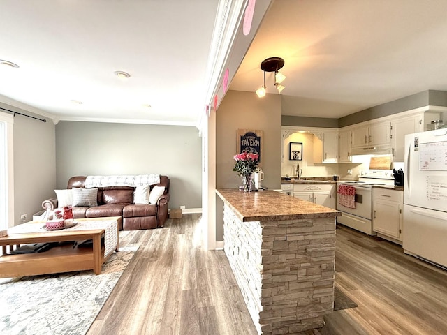 kitchen featuring white appliances, light hardwood / wood-style flooring, sink, kitchen peninsula, and white cabinets