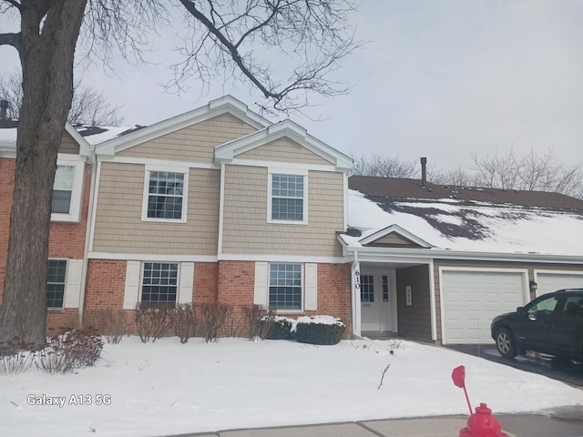 view of front of house with an attached garage, driveway, and brick siding