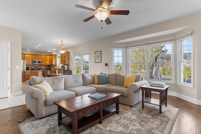 living room featuring recessed lighting, light wood-style flooring, and baseboards