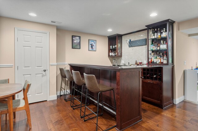 bar with tasteful backsplash, visible vents, dark wood-style floors, wet bar, and recessed lighting