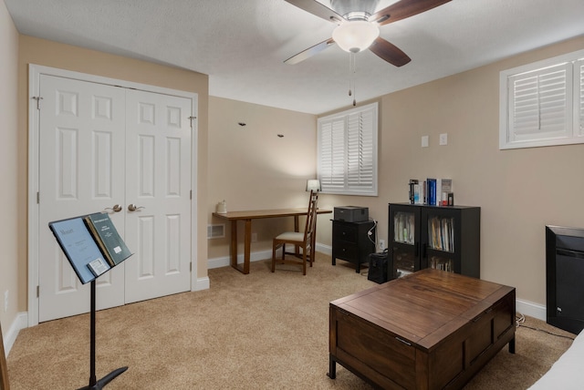 home office featuring a ceiling fan, carpet, visible vents, and baseboards