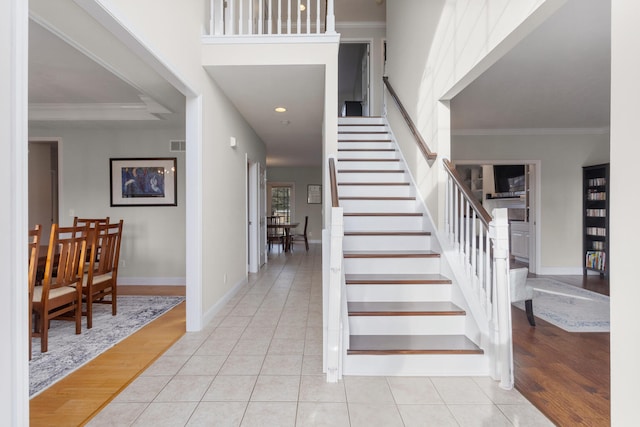 entryway with stairway, tile patterned flooring, and ornamental molding