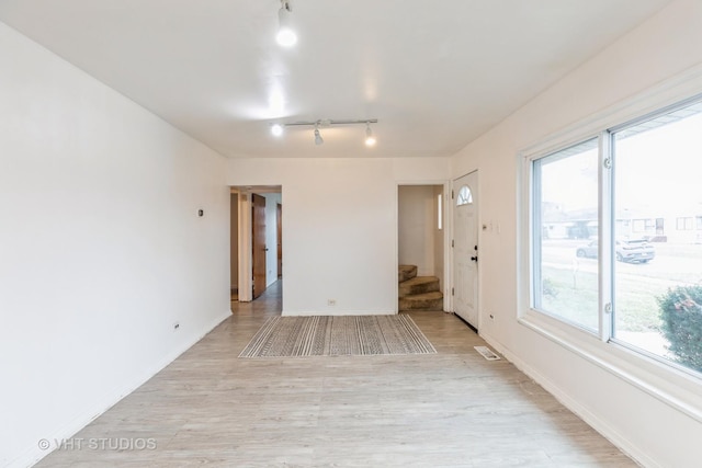 spare room with light hardwood / wood-style flooring and track lighting