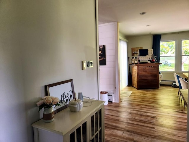 hallway featuring wood-type flooring and baseboard heating