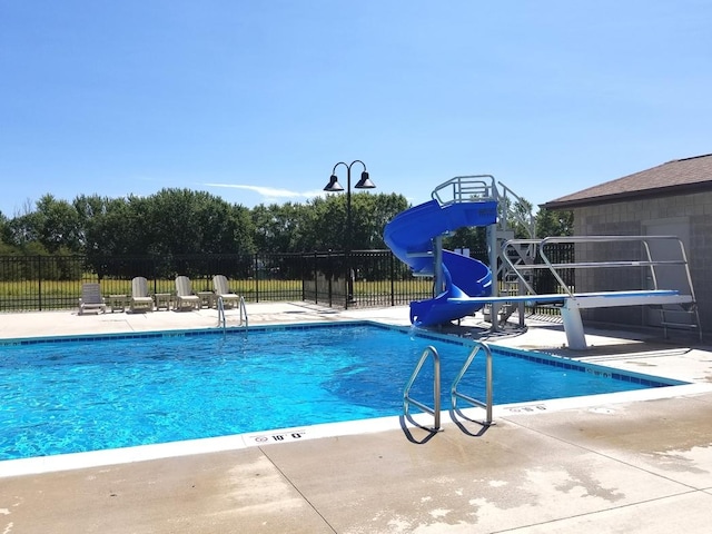 view of swimming pool with a water slide and a playground