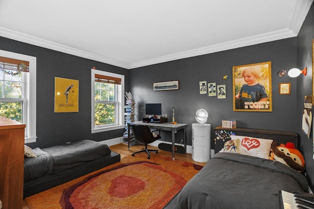 bedroom featuring ornamental molding, wood finished floors, and baseboards