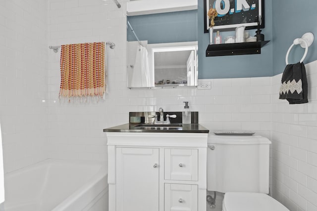 full bath with toilet, shower / bath combo, tile walls, and vanity