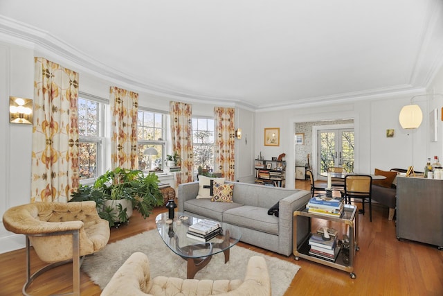 living area with ornamental molding, a wealth of natural light, and wood finished floors