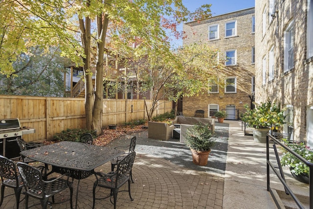 view of patio featuring outdoor dining area, grilling area, and fence