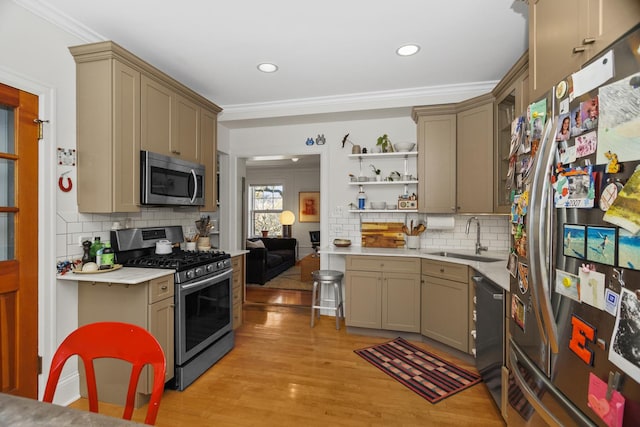 kitchen featuring stainless steel appliances, a sink, light countertops, light wood-type flooring, and open shelves