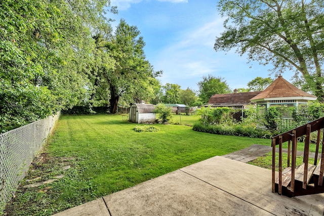 view of yard featuring a storage shed and a patio