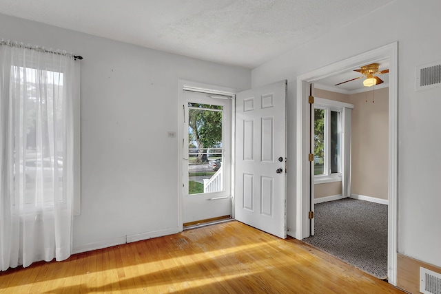 foyer entrance with a healthy amount of sunlight, hardwood / wood-style floors, and a textured ceiling