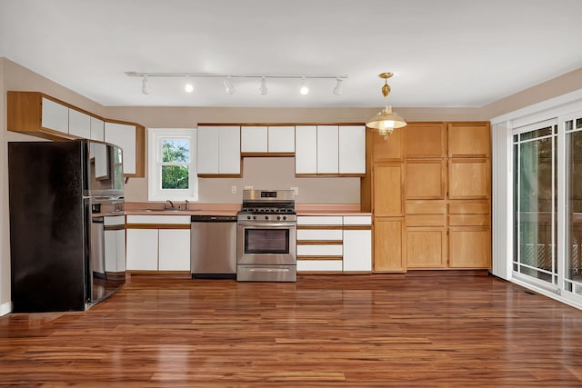 kitchen featuring sink, stainless steel appliances, white cabinets, dark hardwood / wood-style flooring, and decorative light fixtures