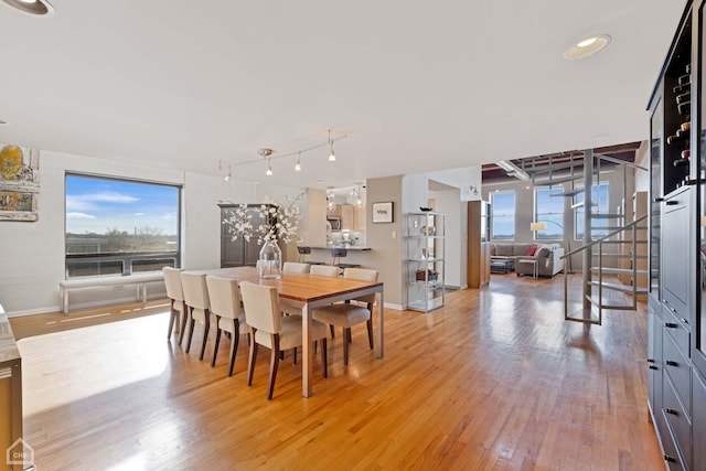 dining space with light wood-type flooring and rail lighting