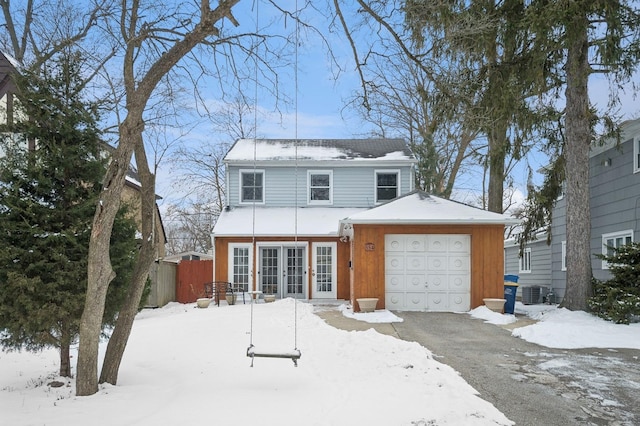 view of front of property with a garage and central AC