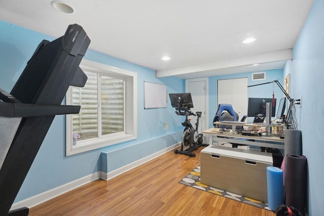 exercise room featuring light wood-type flooring