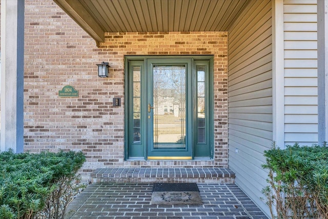 entrance to property featuring brick siding