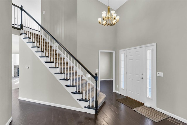 entrance foyer with a chandelier, dark wood-style flooring, visible vents, and baseboards