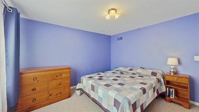 bedroom with light carpet, visible vents, and baseboards