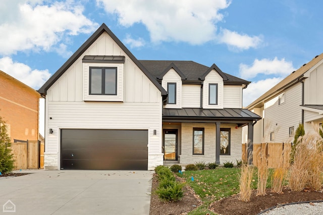 modern farmhouse style home featuring a porch, driveway, stone siding, board and batten siding, and a standing seam roof