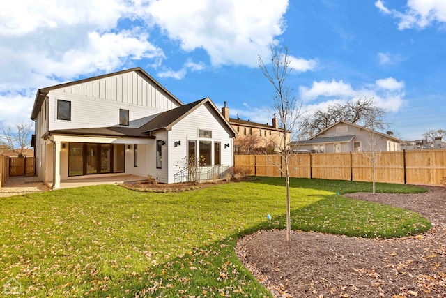 back of property with a patio area, a fenced backyard, a lawn, and board and batten siding