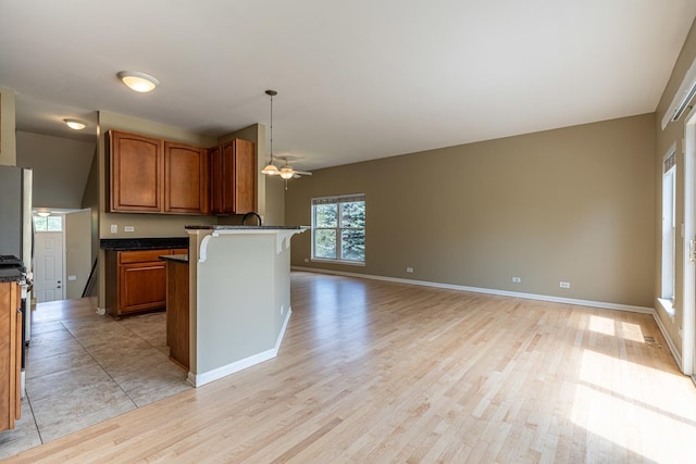 6074 Ironwood Ln, Lisle, IL 60532 - kitchen featuring a breakfast bar area, light wood-type flooring, brown cabinetry, open floor plan, and a peninsula