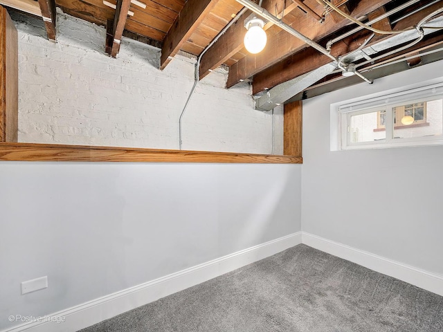 below grade area featuring baseboards and carpet flooring