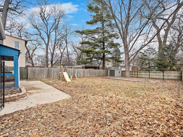 view of yard featuring a patio area, a fenced backyard, a storage unit, and an outdoor structure