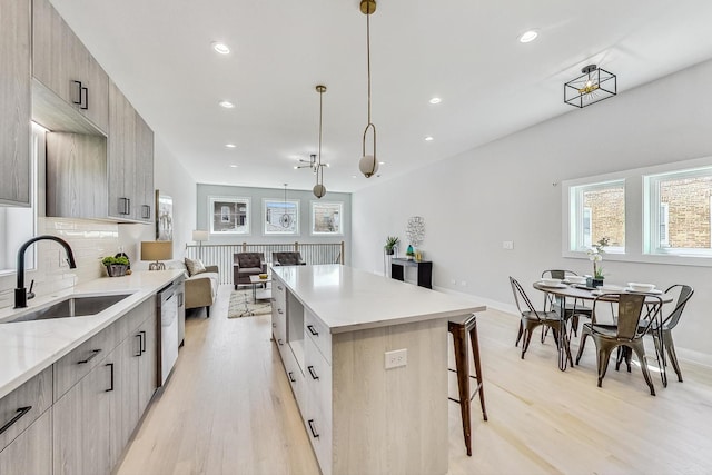 kitchen with pendant lighting, sink, a kitchen island, a kitchen bar, and decorative backsplash