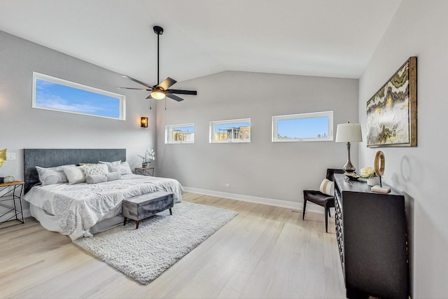 bedroom featuring multiple windows, lofted ceiling, ceiling fan, and light hardwood / wood-style flooring