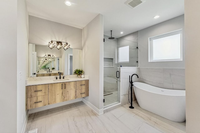 bathroom with vanity and independent shower and bath