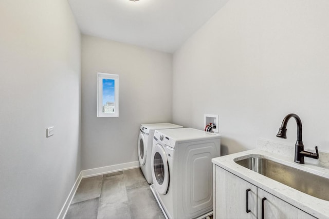 laundry room featuring separate washer and dryer, sink, and cabinets