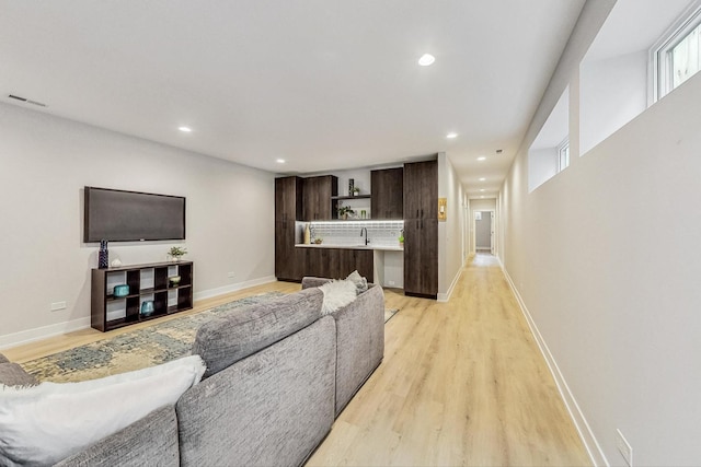 living room with sink and light hardwood / wood-style floors