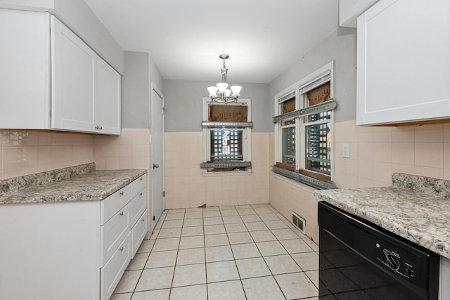 kitchen featuring black dishwasher, white cabinetry, and light countertops