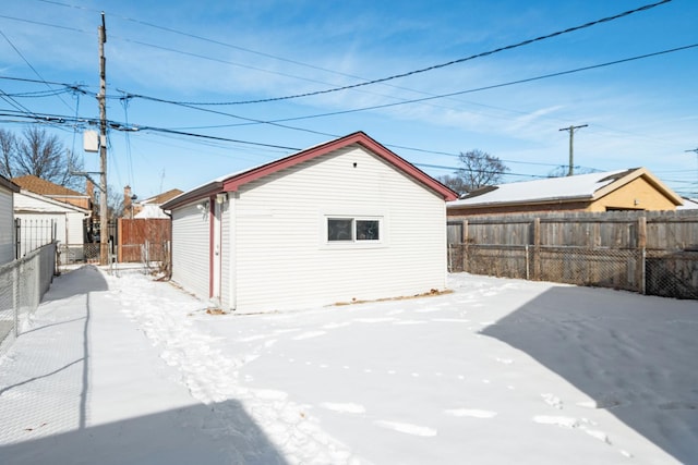 snow covered rear of property featuring fence