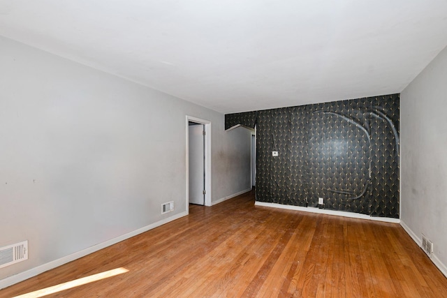 empty room with visible vents and wood finished floors