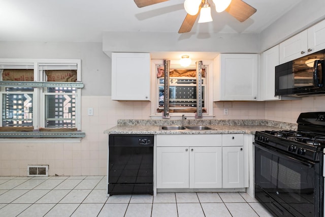 kitchen featuring light tile patterned floors, a sink, visible vents, white cabinets, and black appliances