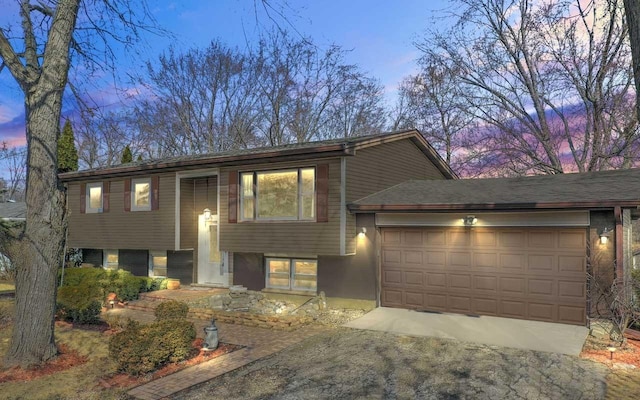 raised ranch with a garage and driveway