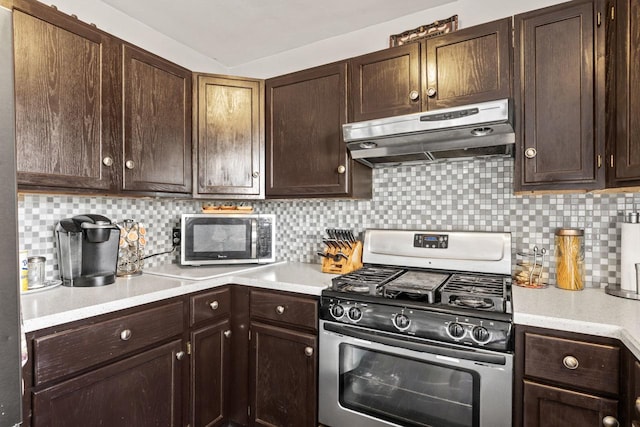 kitchen featuring appliances with stainless steel finishes, light countertops, dark brown cabinetry, and under cabinet range hood