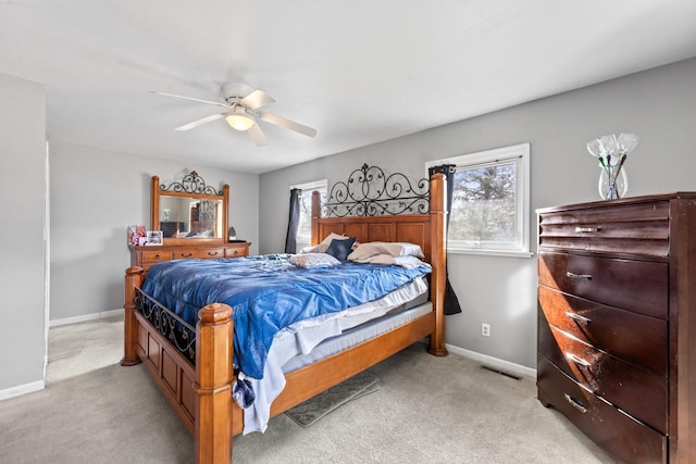 bedroom featuring baseboards, a ceiling fan, visible vents, and light colored carpet