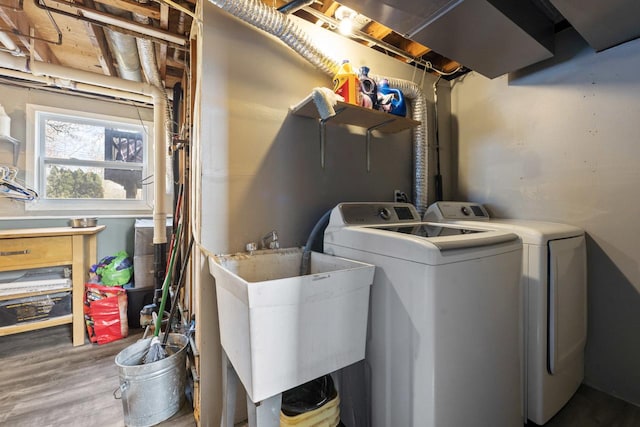 laundry area featuring laundry area, a sink, washing machine and clothes dryer, and wood finished floors