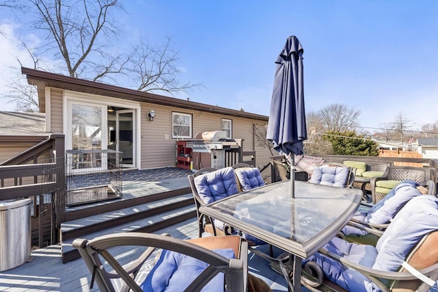 deck with outdoor dining space and a grill