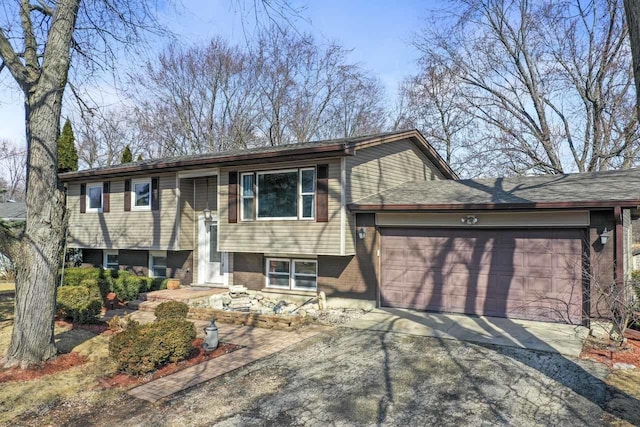 raised ranch with a garage, brick siding, and driveway