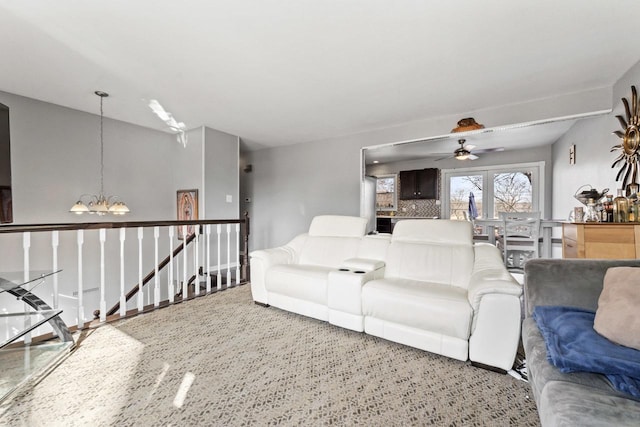 living area with ceiling fan with notable chandelier