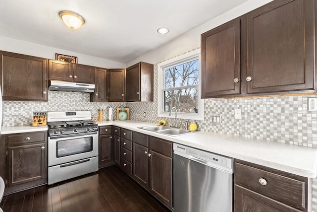 kitchen featuring under cabinet range hood, dark wood-type flooring, a sink, light countertops, and appliances with stainless steel finishes