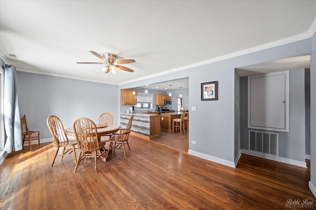 dining room with ornamental molding, visible vents, and dark wood-style floors